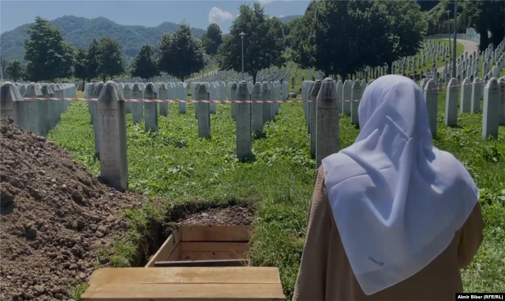 A relative of Mujic looks over the gravesite. &nbsp;