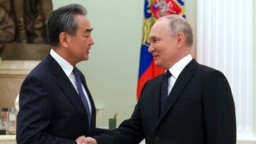 Russian President Vladimir Putin (right) greets Chinese Communist Party foreign policy chief Wang Yi during their meeting at the Kremlin in Moscow on February 22.