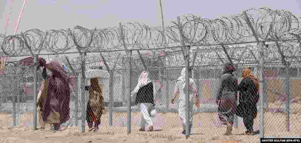 People make their way across the border in Chaman, located in Pakistan&#39;s Balochistan Province, on July 23.&nbsp; Islamabad in October 2023 unilaterally ended the century-old &quot;Easement Rights,&quot; an arrangement that allowed members of Pashtun communities straddling the 19th-century Durand Line border to cross freely to trade and visit extended families.&nbsp;