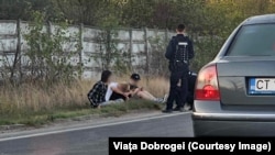 Trei dintre prietenii celor două victime stau pe marginea drumului, la scurt timp după accidentul rutier mortal provocat de Vlad Pascu.