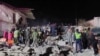 На фото, распространённом МЧС, — спасатели и жители возле обломков обрушенного подъезда дома во 2-м микрорайоне. Жанаозен, 17 апреля 2023 года