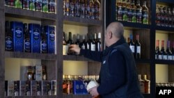 Radnik u prodavnici slaže boce viskija na policu u prodavnici alkoholnih pića u Mosulu, 23. februar 2023.