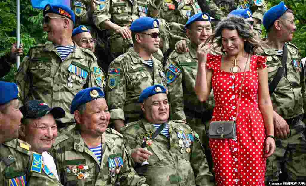  A woman poses for a photo with Kyrgyz veterans next to a monument to Soviet soldiers killed in action in Afghanistan during the Soviet invasion of 1979-1989, marking the annual Combat Veterans Day at Poklonnaya Hill War Memorial Park in Moscow. &nbsp; 