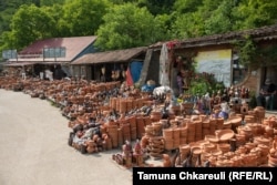 Ceramics made in the village of Shrosha are piled by the roadside and sold by vendors to travelers and tourists. The new highway will bypass Shrosha, depriving the vendors of a vital economic link.