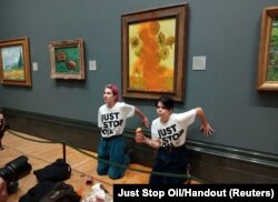 Aktivisti Just Stop Oila lijepe ruke na zid nakon što su gađali "Suncokrete" u Nacionalnoj galeriji u Londonu, Britanija 14. oktobar 2022. ​
