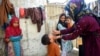 A health worker administers polio drops to a child during a door-to-door vaccination campaign in Karachi. 