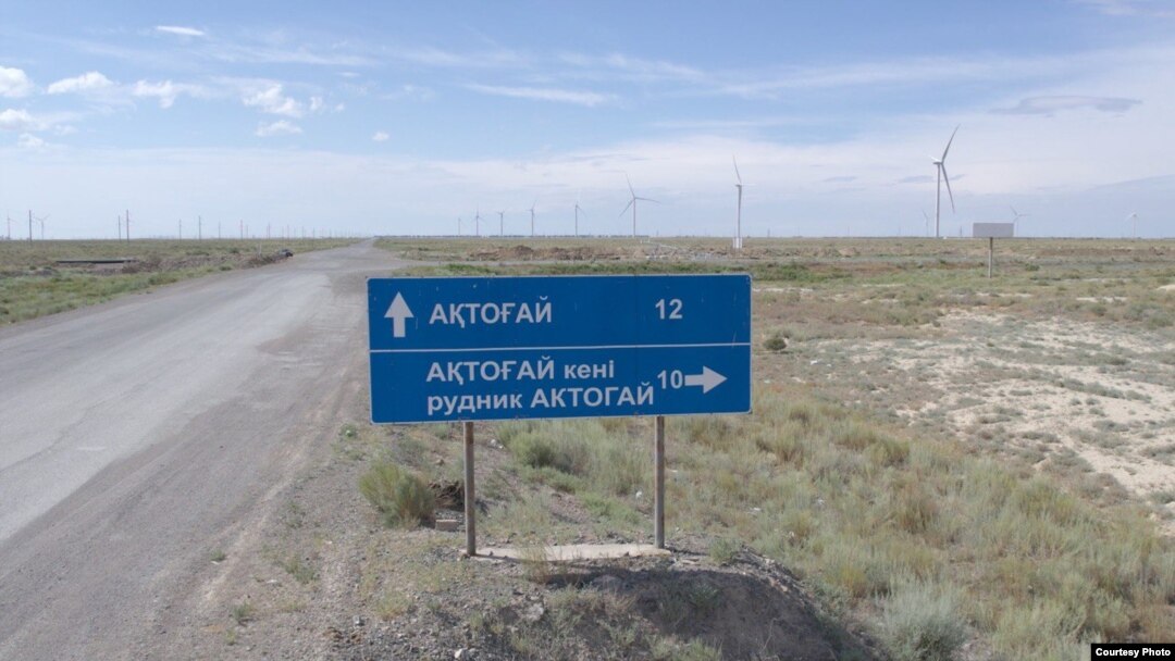 A road sign indicates the direction to Aqtoghai.
