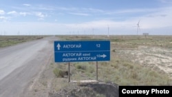 A road sign indicates the direction to Aqtoghai.