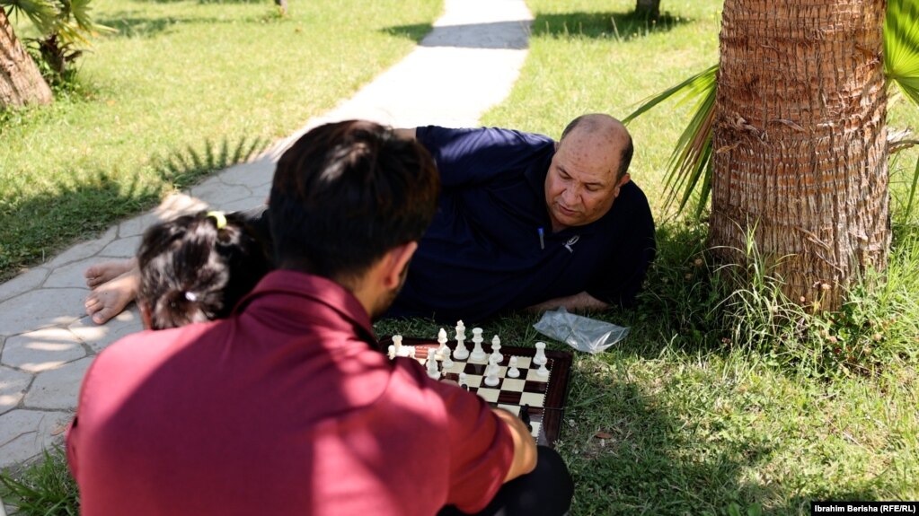 Musa Muhiti, refugjat afgan duke luajtur shah në një park në Shëngjin të Shqipërisë.