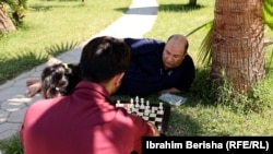 Musa Muhiti, refugjat afgan duke luajtur shah në një park në Shëngjin të Shqipërisë.