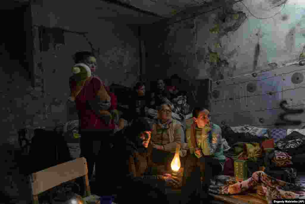 Janna Goma (jobbra) és szomszédai egy mariupoli lakás pincéjében rendezkedtek be. A kép&nbsp; 2022. március 6-án készült róluk. (Evgenij Maloletka, AP) - World Press Photo:&nbsp; Európa, történetek díj