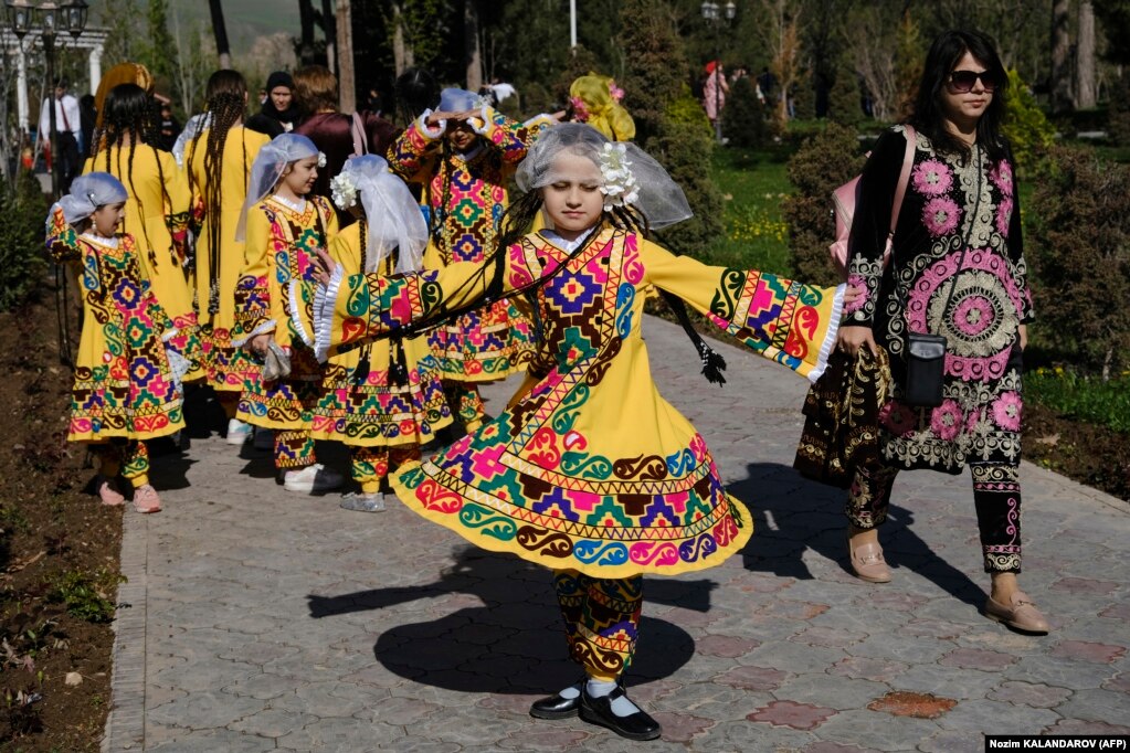 A Tajik girl spins in her colorful traditional dress in Dushanbe.