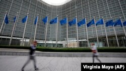 Dy persona kalojnë para selisë së Komisionit Evropian. Fotografi ilustruese nga arkivi. 