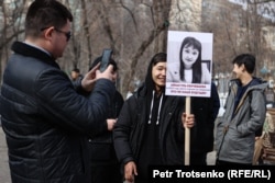 Участник митинга «За достойную жизнь женщин» с портретом женщины, погибшей от бытового насилия. 7 марта 2024 года