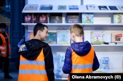 Школярі розглядають книги на українському стенді під час книжкової ярмарки у Брюсселі