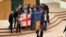 Opposition lawmakers in Georgia's parliament celebrate revoking the bill on "foreign agents" with the flags of Georgia and the EU on March 10.
