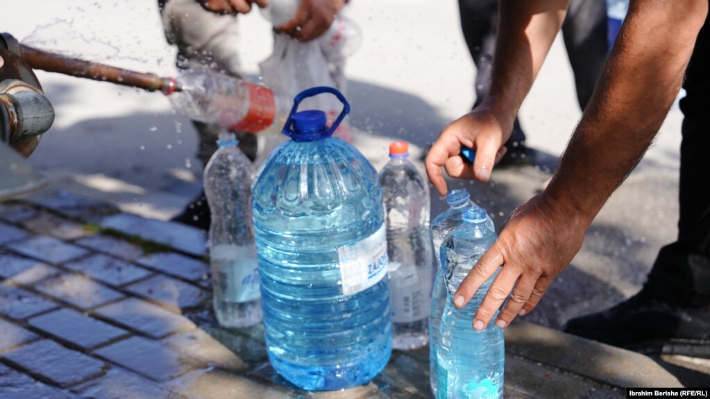 Qytetarët duke mbushur shishe me ujë në autobotet e kompanisë rajonale të ujësjellësit "Prishina".