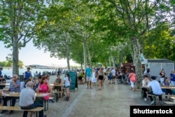 Turistët e mbledhur në bregun e liqenit Balaton për të ndjekur një festival peshku më 2019.
