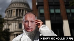 A protester with a face mask of Russian President Vladimir Putin takes part in a rally in London as part of the International "Putin Is A Killer" day of action across Europe on August 20.