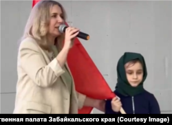Девочка в костюме "бабушки с красным флагом"