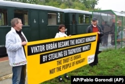 Az Együtt párt aktivistái tüntetnek Orbán Viktor szülőfalujában, Alcsútdobozon 2017-ben, az EP költségvetési bizottságának látogatásán