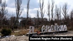 Повреден знак с надпис „Обичам Авдиивка“ сред опустошения град в Донбас, 28 март 2023 г.