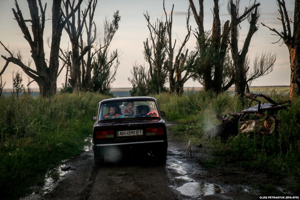 Una famiglia di ucraini trasporta oggetti dalla loro casa, distrutta durante l'invasione russa dell'Ucraina, ad un altro villaggio.  Villaggio di Davgenka, regione di Kharkiv, Ucraina, 15 luglio 2023 