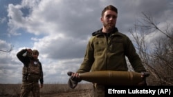 Українські військові несуть снаряди для ураження російських позицій на передовій поблизу Бахмута, 25 березня 2024 року
