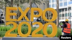 Radnici ispred logotipa Expo 2020 uoči ceremonije otvaranja u Dubaiju, Ujedinjeni Arapski Emirati, 30. septembra 2021.