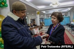 Первый избиратель на участке № 254 в Алматы получает подарок. 19 марта 2023 года