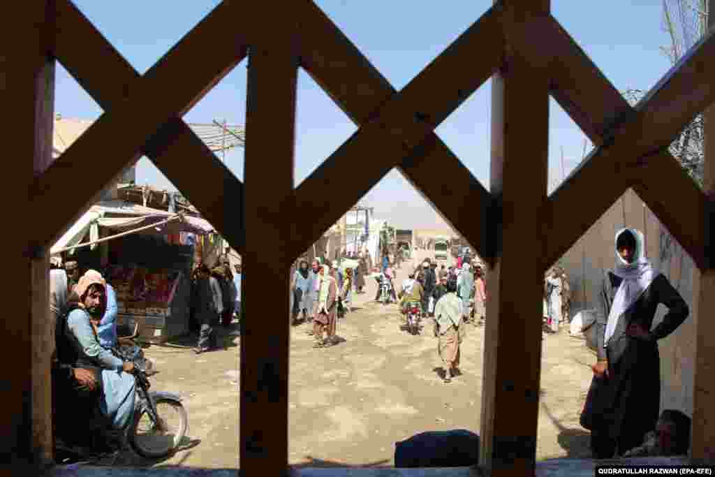 People wait to cross into Pakistan at the Spin Boldak border crossing in Afghanistan on July 22. After a nine-month closure that incited violent protests by angry residents and traders, Islamabad on July 21 announced that it will reopen the Spin Boldak border crossing point in Chaman.