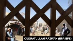 People wait to cross into Pakistan at the Spin Boldak border crossing in Afghanistan on July 22.<br />
<br />
After a nine-month closure that incited violent protests by angry residents and traders, Islamabad on July 21 announced that it will reopen the Spin Boldak border crossing point in Chaman.