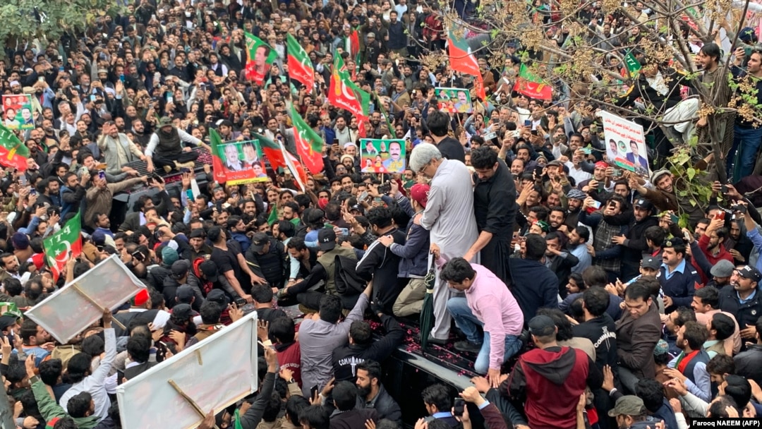 Supporters gather around a car carrying Pakistan's former Prime Minister Imran Khan (not pictured) after he appeared at a court in Islamabad on February 28.