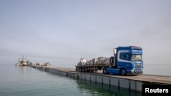 Një kamion transporton ndihma humanitare përmes portit të përkohshëm të SHBA-së në Gazë. 19 maj 2024. 
