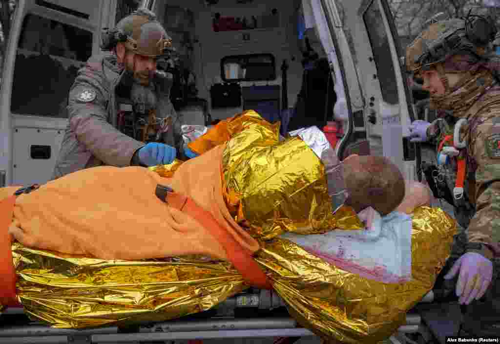Medics carry a wounded Ukrainian soldier to an emergency vehicle before heading to a hospital outside a frontline medical stabilization point amid Russia&#39;s attack on Ukraine.