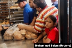 Palestinians wait to buy bread outside a bakery in Khan Younis in the southern Gaza Strip on October 14.