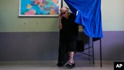 Грција - Жена гласа на избирачко место. 