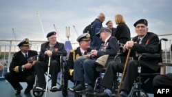 Britanski veterani razgovaraju s vojnim oficirom na palubi trajekta Brittany Ferries tokom putovanja u Francusku, 4. juna 2024.