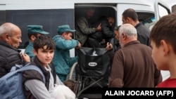 Беженцы садятся в автобус на выходе из регистрационного центра Красного Креста в Горисе. Армения, 25 сентября 2023 года