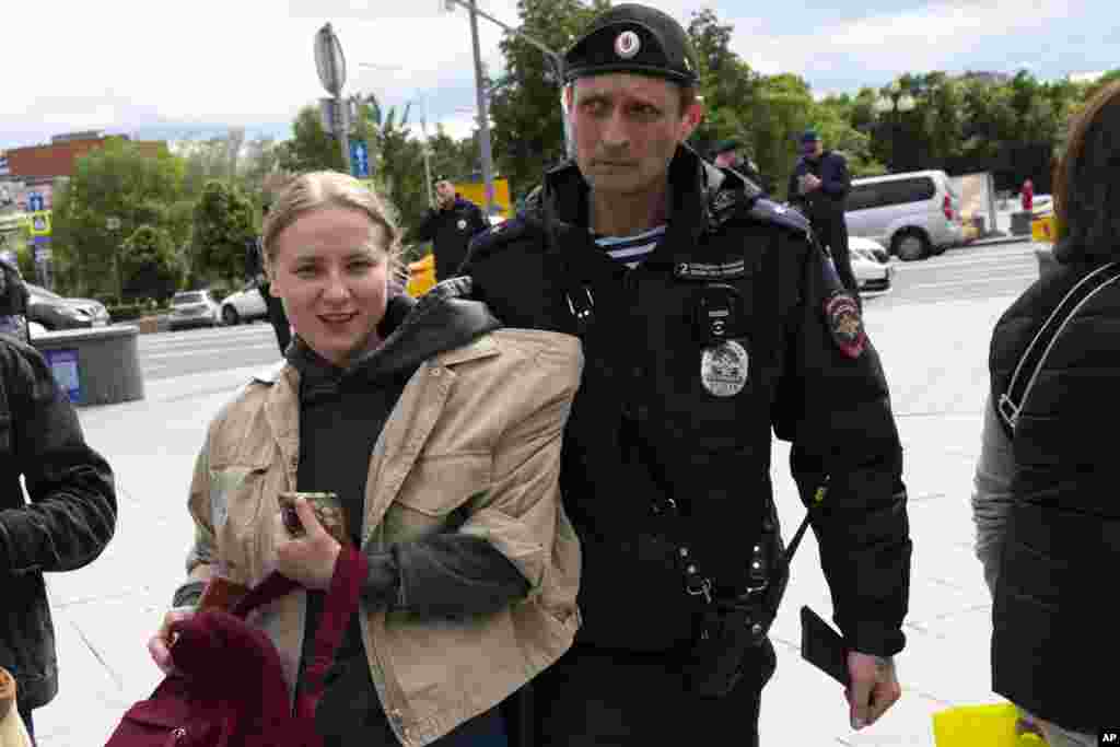 A demonstrator smiles as she is detained in Moscow&#39;s Pushkinskaya Square. Supporters in open defiance of Putin&#39;s crackdown on any dissent held pickets in cities throughout Russia. The protest-monitoring group, OVD-Info, reported that more than 100 people were arrested at&nbsp;pro-Navalny rallies in 23 Russian cities.