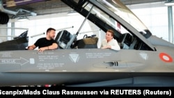 Президент Украины Владимир Зеленский и премьер-министр Дании Мэтте Фредериксен сидят в истребителе F-16 на авиабазе Скридструп в городе Военс, Дания, 20 августа 2023 года