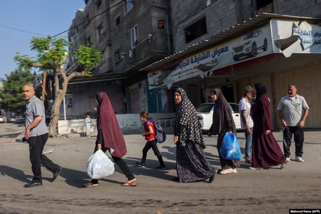 Palestinezët duke mbajtur disa gjëra në duar shihen duke u larguar drejt zonave më të sigurta në qytetin e Gazës pas sulmeve ajrore izraelite, më 13 tetor 2023. 