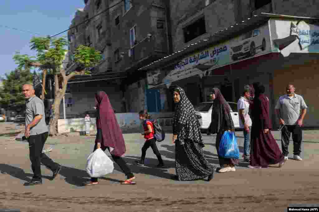 Palestinezët duke mbajtur disa gjëra në duar shihen duke u larguar drejt zonave më të sigurta në qytetin e Gazës pas sulmeve ajrore izraelite, më 13 tetor 2023.&nbsp;