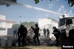 Francuski policajci koriste vodene topove kako bi rastjerali demonstrante u luci La Rochelle, 20. juli 2024.