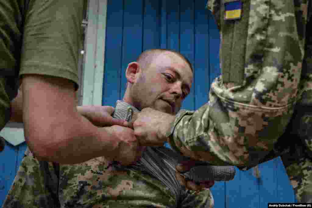 First-aid techniques are demonstrated on a recruit who was convicted of manslaughter. Over 3,000 prisoners have been paroled and assigned to military units after their recruitment was approved by parliament in a controversial mobilization bill.