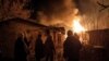Lokalno stanovništvo stoji u blizini zapaljene zgrade nakon ruskog vojnog napada u gradu Časiv Jar, u oblasti Donjecka, Ukrajina, 28. februara 2023.