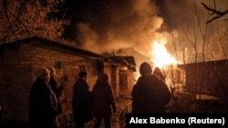  Жители на Часив Яр, който се намира покрай Бахмут следят пожар породен от съветска пукотевица. 