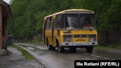 A bus makes its way along the only route into Glola.