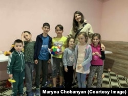 Дівчина разом з українськими дітьми-біженцями