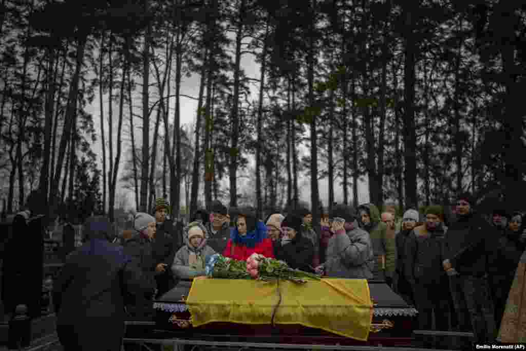 Relatives mourn next to the body of a Ukrainian soldier during his funeral in Kalynivka, near Kyiv.